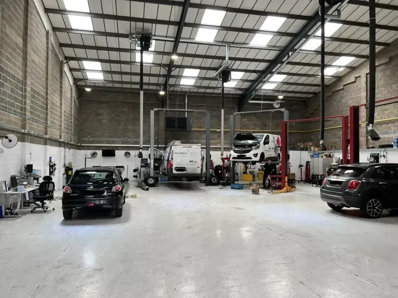 The Hopfields workshop floor — four two-post lifts under a high, bright roof